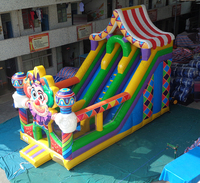 Structure gonflable géante de cirque avec toboggan, château gonflable, échelle d'escalade et double piste de glisse, équipement de parc d'attractions pour carnaval