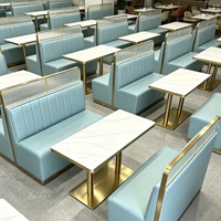 Table de restaurant en pierre frittée sur mesure avec structure métallique et sièges muraux adjacents pour hôtel et café