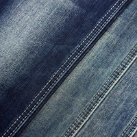 Tissu denim brut à faible rétrécissement (3 %), forme stable, texture slub non lavée, mélange coton-polyester, denim rigide