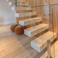 Escalier flottant pour résidence moderne avec marches en noyer massif et supports en acier dissimulés