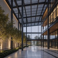 Grande structure de centre d'exposition en acier avec poutres de toit apparentes, entrée en verre et espace de réception paysagé pour événements