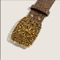 Cette ceinture rétro présente une boucle croisée en alliage noir à motifs floraux en relief et ornée de découpes argentées, d'une esthétique western classique.