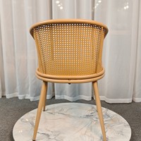 Fauteuil de salle à manger moderne nordique avec dossier incurvé enveloppant, assise en cuir sur structure claire, idéal pour appartement, salle de bain et atelier