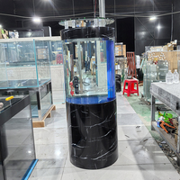 Aquarium cylindrique sur pied en verre avec meuble finition marbre noir et filtre intégré pour la décoration intérieure