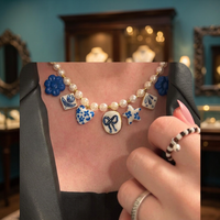 Collier élégant avec pendentif en perles de céramique blanches et cœur en émail bleu