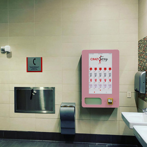 Distributore automatico a parete di colore rosa per articoli per l'igiene
