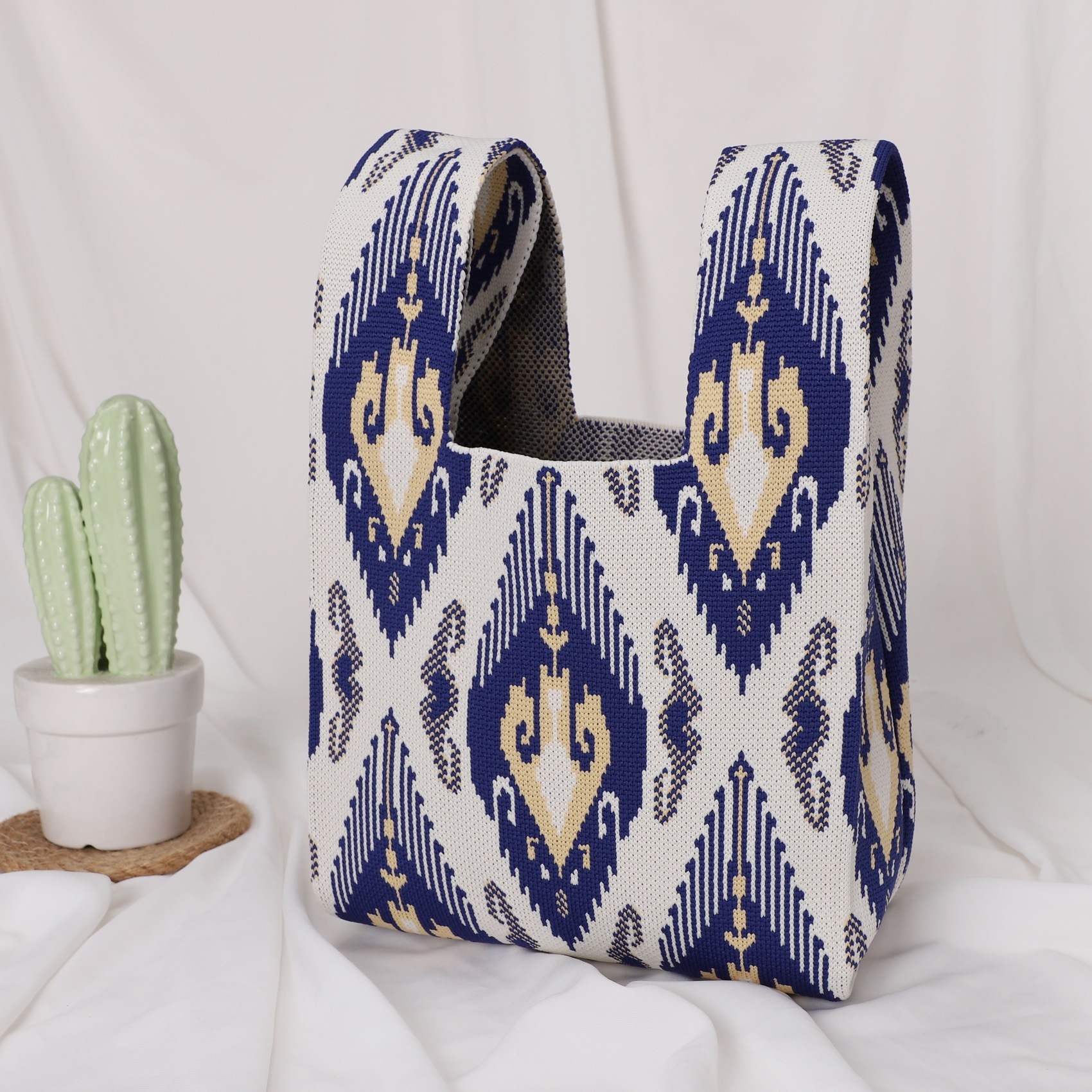 Petit sac bleu foncé et blanc à motif de flèches en losange.