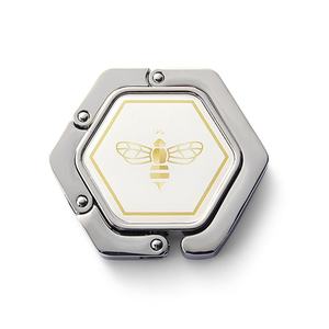 Gancho de Mesa Portátil Hexagonal Único y Moderno para Bolsos, Plegable, Metálico - Product Image 1