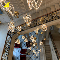 Lustre suspendu LED en forme de goutte d'eau avec accents dorés pour grandes escalinades et espaces à plafond haut – Éclairage de luxe personnalisable