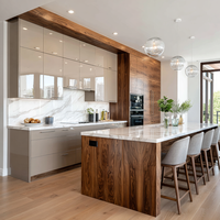 Meubles de cuisine modernes en placage de bois sur mesure avec portes brillantes, îlot central avec sièges et rangements hauts pour projets