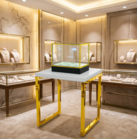 Vitrine en verre sur pied avec cadre en métal jaune, table en acier, plateau blanc, présentoir pour bijoux et montres, stand de vente au détail, showroom personnalisé