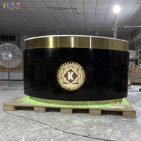 Table de réception incurvée de luxe en Corian noir et or pour clinique esthétique, centre de bien-être, avec logo LED intégré