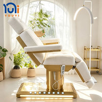Lit de beauté électrique en cuir de luxe moderne avec base dorée, fonction massage, lumières intégrées pour salon de coiffure, hôtel, soins du visage et extensions de cils