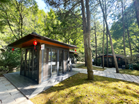 Maison en bois contemporaine avec un design géométrique et des murs en verre, idéale pour un hôtel boutique avec vue sur la mer ou la forêt