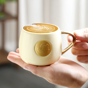 แก้วเซรามิคลายแมว หูจับสีทอง สีครีม สำหรับกาแฟ ชา และเครื่องดื่ม - Product Image 1