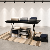 Table de présentation noire avec pieds en X chromés, meuble îlot bas commercial pour vêtements