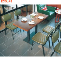 Ensemble de banquettes de restaurant rétro avec bancs rembourrés verts, chaises à lattes et tables en bois.