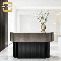Bureau d'accueil moderne haut de gamme avec base verticale cannelée, comptoir d'accueil élégant noir pour hôtel de luxe, bureau d'accueil de salon.