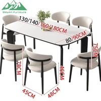 Ensemble de table à manger Wayon moderne avec plateau en marbre blanc, pieds architecturaux noirs, chaises rembourrées