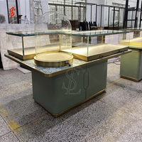 Comptoir de présentation de bijoux avec plateau en marbre, vitrine cloche en verre trempé, bordure en métal doré, table îlot, unités de présentation pour la vente au détail