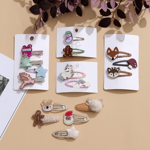 Ensemble de pinces à cheveux en tissu de Noël mignonnes pour enfants avec des motifs de rennes, de pain d'épices et d'unicornes sur un emballage en sac OPP - Product Image 1