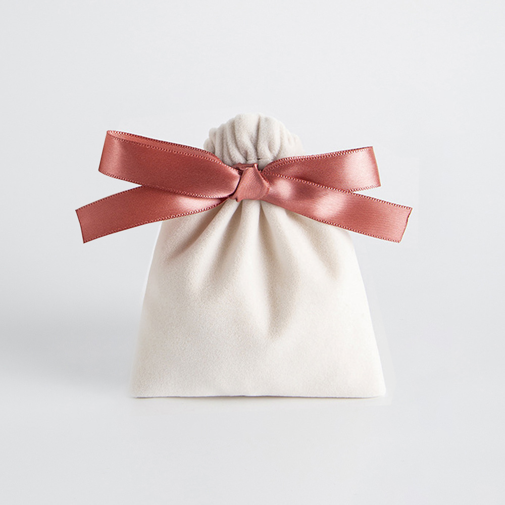 Bolso beige con lazo rosa