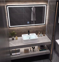 Meuble-lavabo mural en céramique intégré avec vasque en pierre frittée grise au design moderne, comptoir en pierre frittée pour usage hôtelier