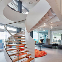 Escalier extérieur moderne courbé avec garde-corps en acier inoxydable et en verre, éclairage LED sur les marches, design durable et écologique