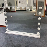 Miroir de maquillage rectangulaire éclairé avec bordure à ampoules et cadre blanc
