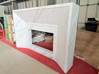 Cheminée électrique en marbre blanc sur mesure, style européen, avec manteau de cheminée sculpté, colonnes et reliefs floraux, pour villa de luxe, intérieur.