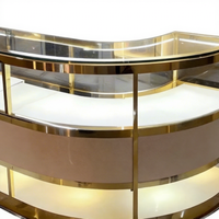 Ensemble de présentoirs de bijouterie moderne avec cadre doré, écoresponsable, éclairage LED, îlot central incurvé et vitrines périmétriques pour la vente au détail de luxe