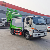 Camion compacteur de déchets HEAVSTY 7 mètres cubes 4x2 à transmission manuelle et chargement arrière, moteur et boîte de vitesses pour bacs de 120L/240L