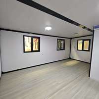 Maison modulaire préfabriquée moderne, maison préfabriquée à ossature en acier noir, maison en kit, bande lumineuse LED, mur en placage de pierre, cour arrière