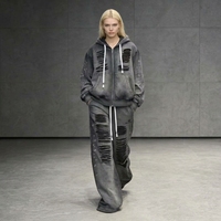 Ensemble streetwear deux pièces ample pour femme, comprenant un sweat à capuche zippé délavé à l'acide et déchiré, et un pantalon de survêtement avec détails à œillets