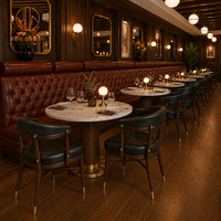 Meubles de restaurant haut de gamme Ron Group, banquettes capitonnées à dossier haut en cuir, table ronde en marbre