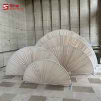 Décor de mariage élégant : Arche de toile de fond semi-circulaire avec supports en forme d'éventail et draperies