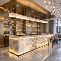 Îlot de cuisine en marbre rétroéclairé sur mesure, comptoir de bar cascade en pierre translucide lumineuse à LED, évier, panneau en bois, cuisine ouverte de villa