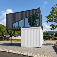 Maison préfabriquée contemporaine en conteneur à deux étages, avec toit en pente imitation bois, mur entièrement vitré et design cantilever.