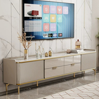Meuble TV moderne de luxe léger, buffet avec plateau en pierre frittée blanche et portes de placard cannelées, pieds surélevés en métal doré, rangement
