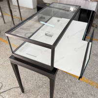 Vitrine à bijoux autoportante en verre avec cadre noir, pieds hauts et éclairage LED pour les bijouteries professionnelles