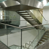 Escalier droit moderne et contemporain pour intérieur, à double poutre, structure acier-bois, garde-corps en verre, marches en pierre