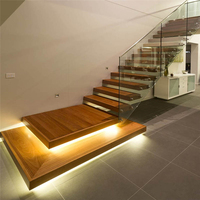 Escalier intérieur moderne de luxe avec garde-corps en verre, éclairage LED, marches en bois, escalier droit flottant