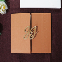 Invitation de mariage traditionnelle en couverture rigide marron café avec bordure gaufrée et monogramme en acrylique doré pour mariage culturel
