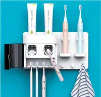 防塵カバーと2つの歯磨き粉スクイーザー、2つの電動歯ブラシホルダーを備えたダブル自動歯磨き粉ディスペンサー