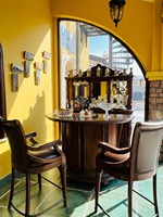 Meuble bar de style méditerranéen en bois vieilli avec casier à vin intégré pour 12 bouteilles, sculptures d'acanthe et pieds en laiton