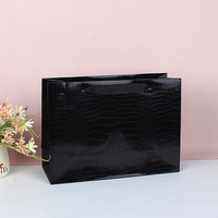 Sac en papier noir personnalisable avec motifs lézards et crocodiles, film brillant, sac cadeau haut de gamme et tendance pour magasin de vêtements