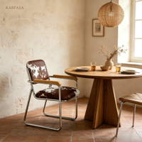 Fauteuil cantilever en cuir de vachette avec structure chromée et accoudoirs en bois, style Mid-Century Modern, motif marron et blanc, pour bureau, salle à manger ou salon.