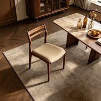 Chaise de salle à manger en bois massif avec dossier à double lattes et coussin noir sur pieds coniques pour restaurant, brasserie et salon de thé