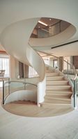 Escalier préfabriqué courbé en acier et bois, durable, avec garde-corps en verre intérieur et marches antidérapantes
