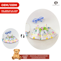 Peluche Teddy ISLAND sous licence mondiale avec robe florale à carreaux colorée, pendentif appareil photo et nœud rose